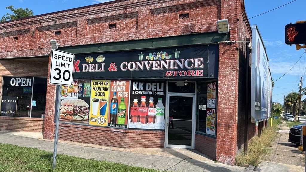 The red brick corner storefront of KK Deli seen from the sidewalk on Gloucester Street.