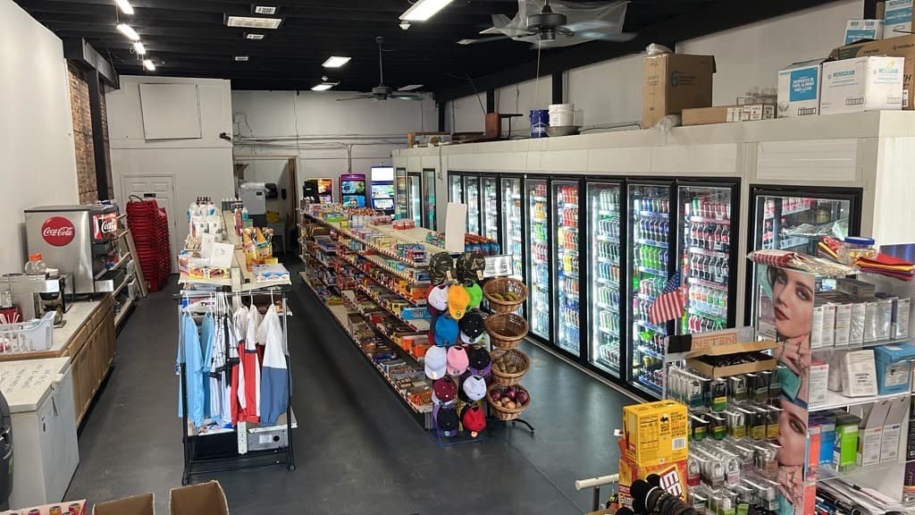 The main shopping aisle running toward the drink coolers at the back of the store.